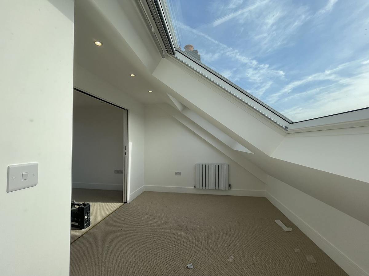 A finished loft room in Hertfordshire with a long roof light in the slope